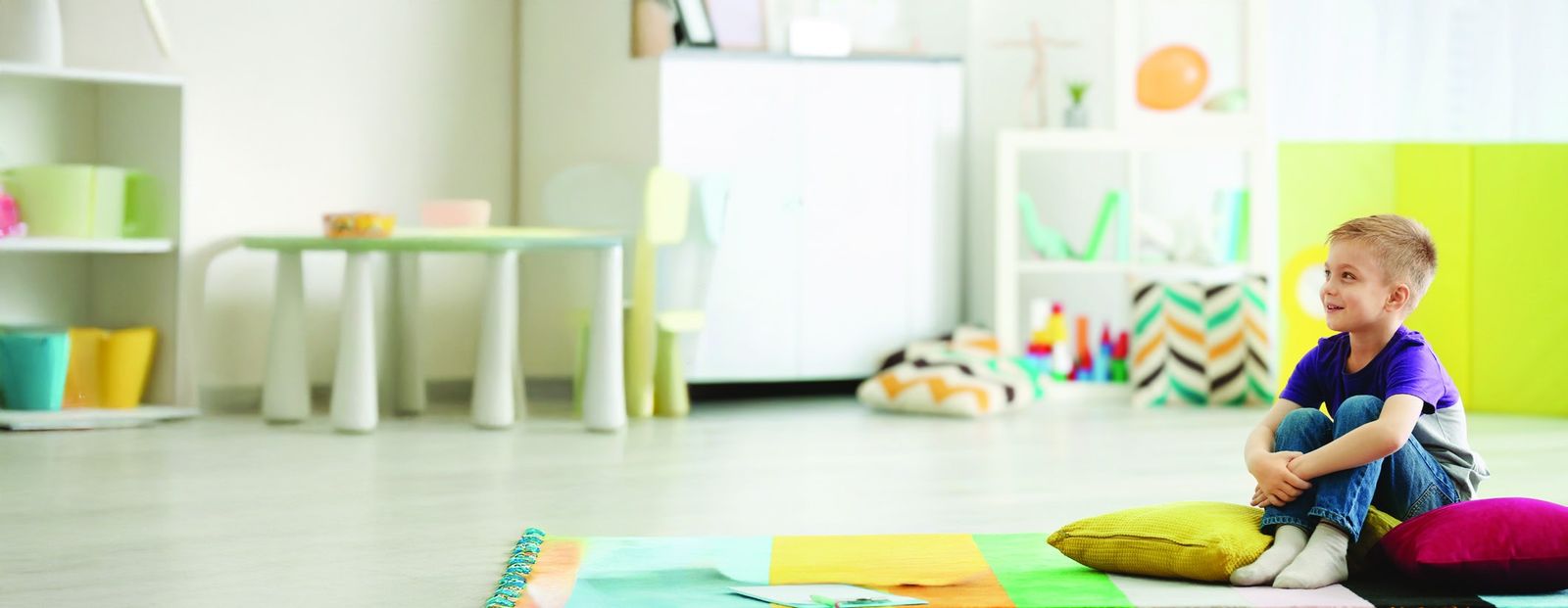 A young boy relaxing on cushions in a bright playroom